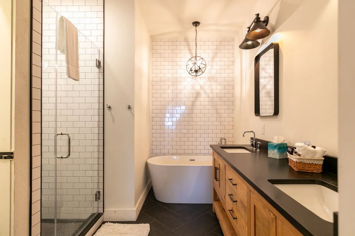 A luxurious bathroom with a freestanding soaking bathtub, double vanity, and a glass-enclosed shower. Soft lighting and elegant finishes create a spa-like atmosphere ideal for relaxation and self-care.